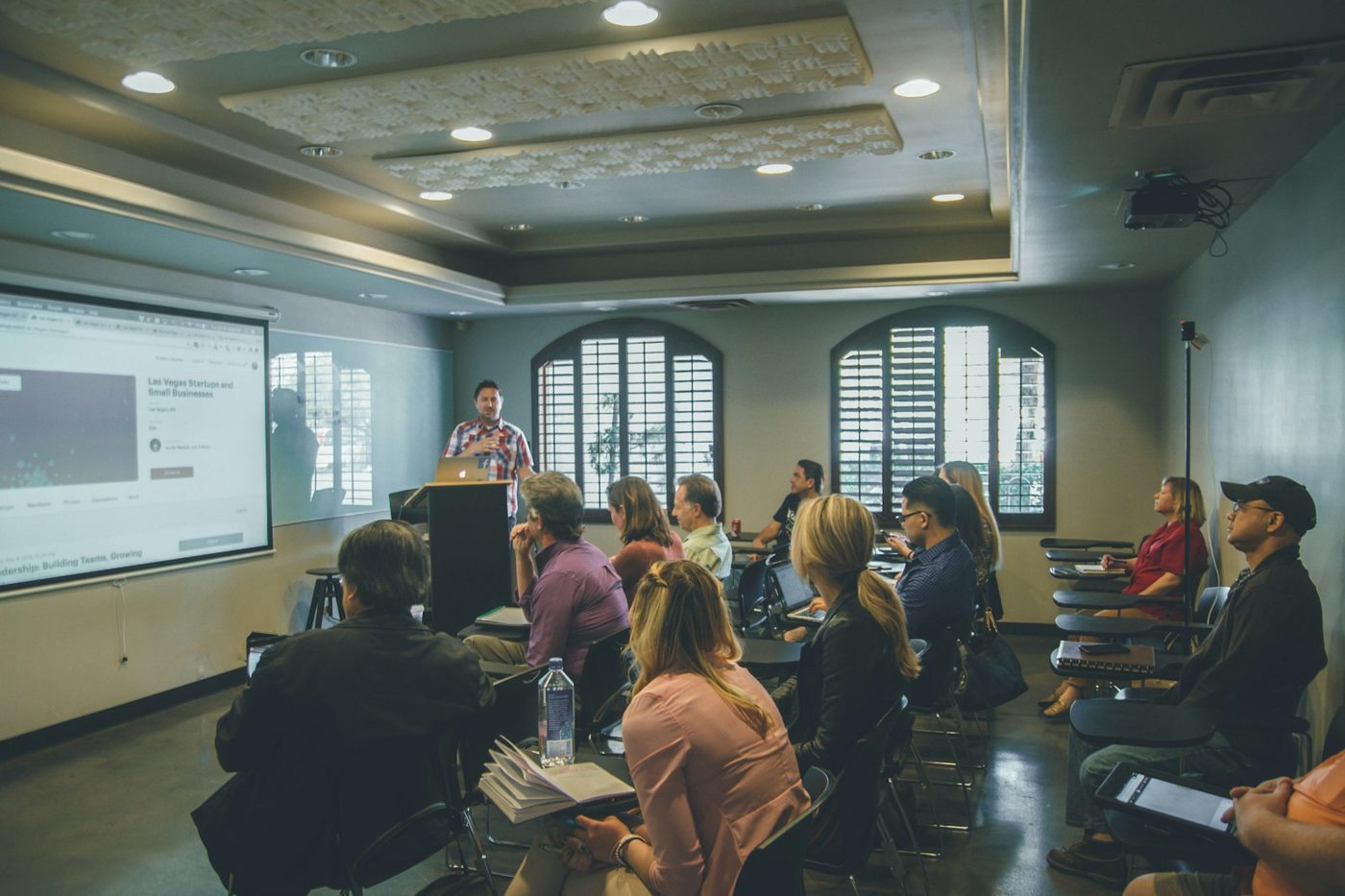 A facilitator leading a session with a group seated in a workshop room